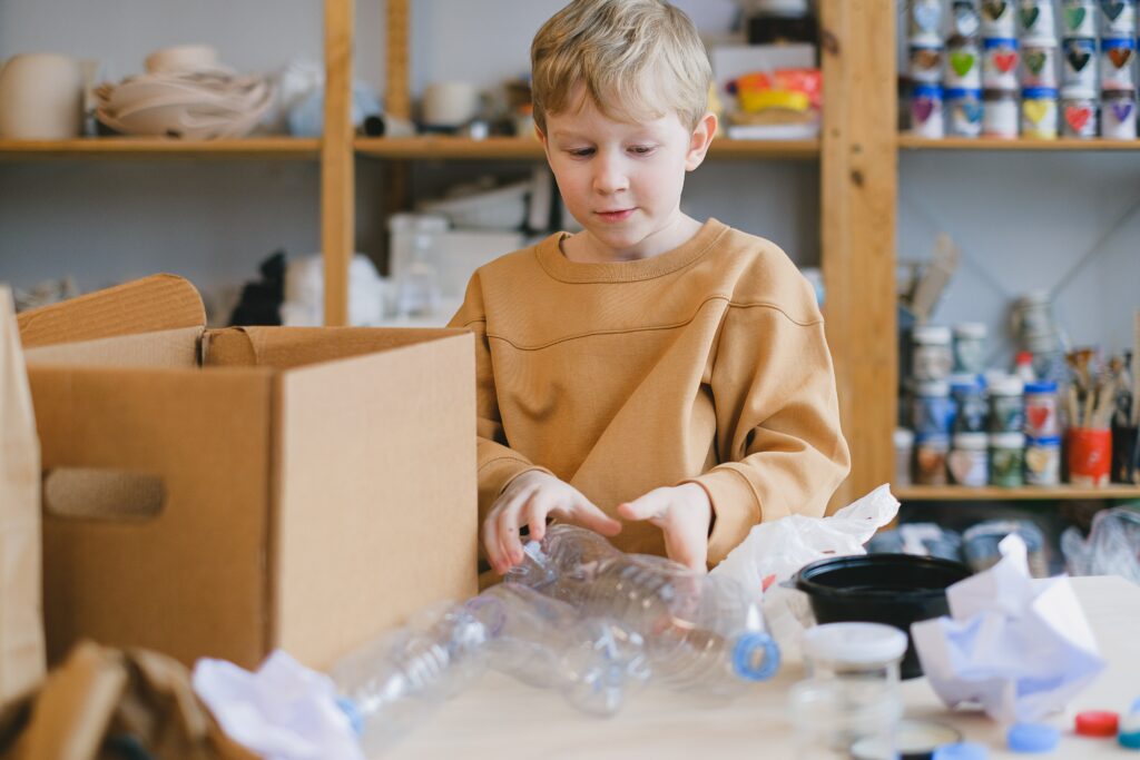 Junge nutzt gebrauchte Plastikflaschen für Windspiele
