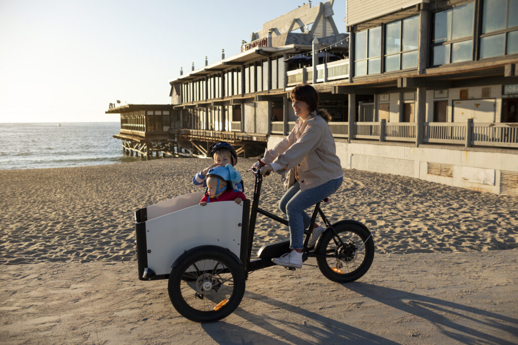 Mutter mit zwei Kindern auf Lastenrad