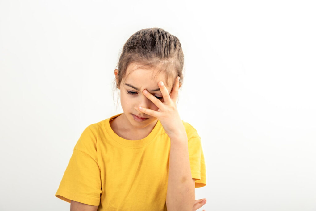 Gehirnerschütterung bei Kindern kann sich durch Kopfschmerzen zeigen. 