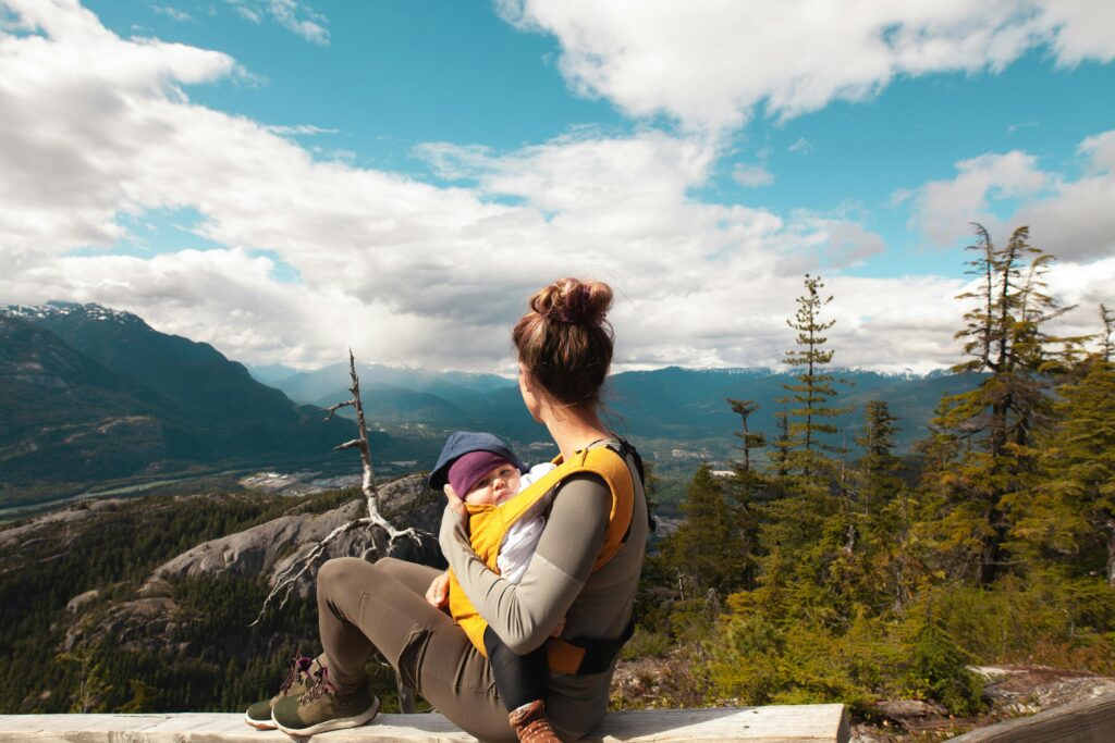 Mutter mit Trage beim Wandern mit Kindern
