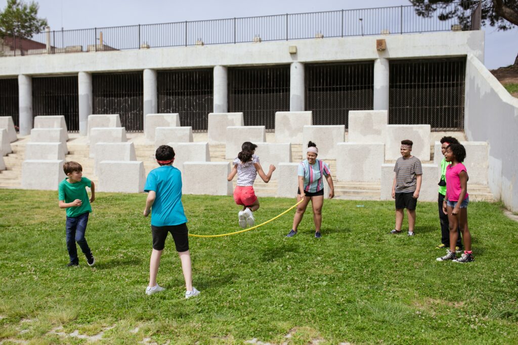 Eine Gruppe Kinder spielt Seilspringen im Freien