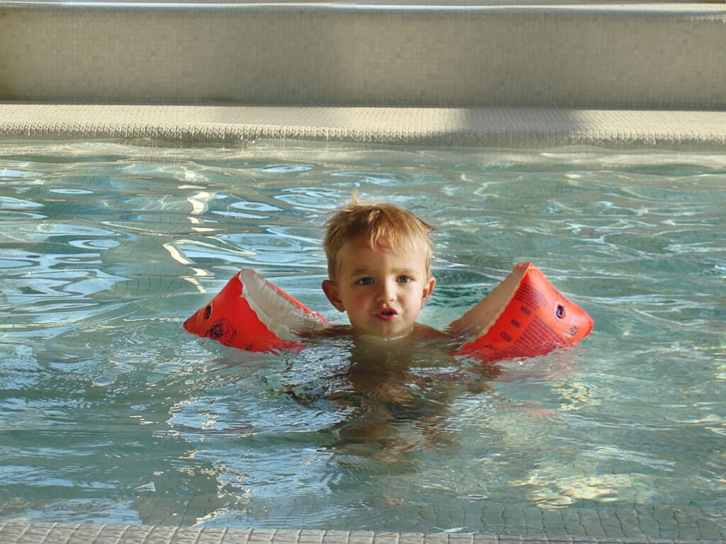 Kind nutzt Schwimmflügel als Schwimmlernhilfen